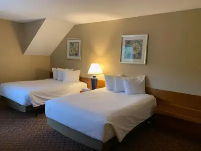 a hotel room with two beds and a lamp at Pocono Villas Resort in East Stroudsburg
