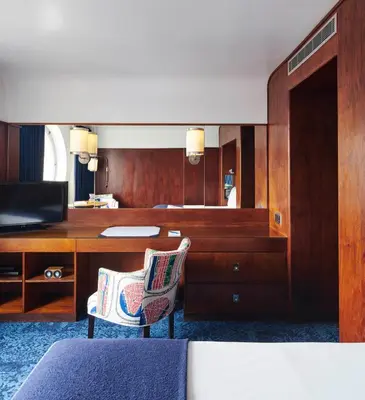 a hotel room with a desk and a bed and a room at The Maritime Hotel in New York