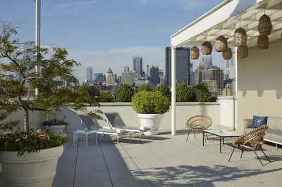 a patio with chairs and tables and a city skyline at The Maritime Hotel in New York