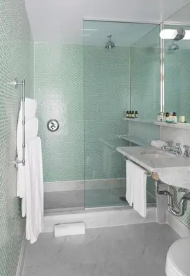 a bathroom with a glass shower and a sink at The Maritime Hotel in New York