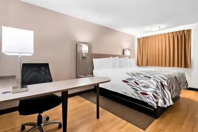 a hotel room with a bed and a desk at Red Roof Inn Harrisburg North in Harrisburg