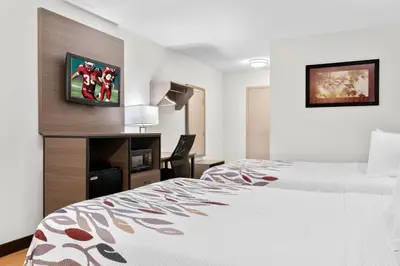 a hotel room with a bed and a tv at Red Roof Inn Harrisburg North in Harrisburg