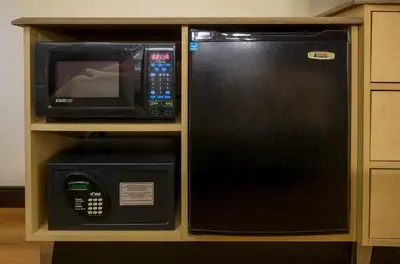 a microwave and a microwave oven in a cabinet at Red Roof Inn Harrisburg North in Harrisburg
