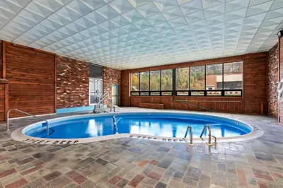 a swimming pool in a room with a brick wall at Days Inn by Wyndham Liberty in Ferndale