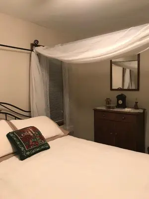a bedroom with a white bed and a mirror at Mill Stone - Mt Penn Lodging in Mount Penn