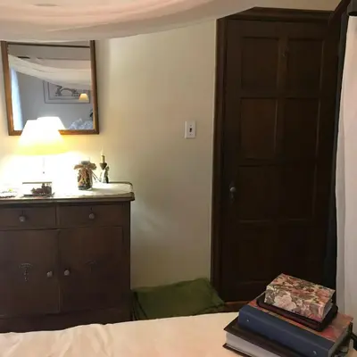 a bedroom with a bed with a dresser and a mirror at Mill Stone - Mt Penn Lodging in Mount Penn