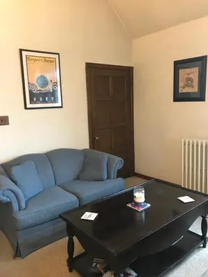 a living room with a blue couch and a coffee table at Mill Stone - Mt Penn Lodging in Mount Penn