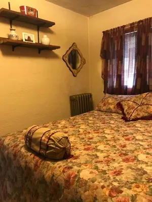 a bedroom with a bed with a flowered bedspread at Mill Stone - Mt Penn Lodging in Mount Penn