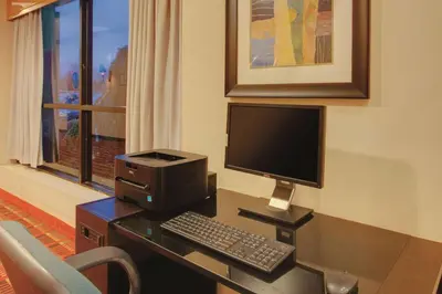 a desk with a computer and a keyboard and monitor at Ramada Inn by Wyndham Fairfield NJ in Fairfield