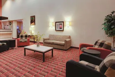 a living room with couches and a coffee table at Ramada Inn by Wyndham Fairfield NJ in Fairfield