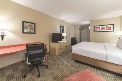 a hotel room with a bed and a desk and a chair at Ramada Inn by Wyndham Fairfield NJ in Fairfield