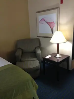 a hotel room with a chair and a lamp at Wingate by Wyndham - York in York