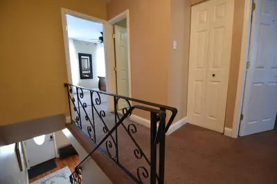 a hallway with a staircase with a white door at Tuscany 2900 - Classic Italian Style 3BR w Parking near Airport in Philadelphia