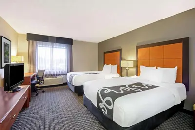 a hotel room with two beds and a television at La Quinta by Wyndham Harrisburg Airport Hershey in Harrisburg
