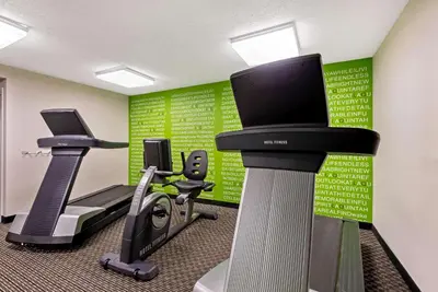 a gym with two tread machines and a flat screen tv at La Quinta by Wyndham Harrisburg Airport Hershey in Harrisburg