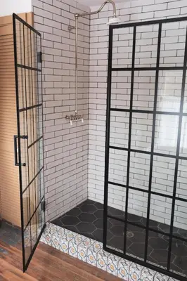 a shower with a black and white tile wall at Stonehill's Farmhouse in Accord
