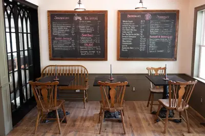 a dining room with a table and chairs and a chalkboard at Stonehill's Farmhouse in Accord
