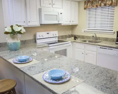 a kitchen with white cabinets and blue dishes on a counter at Tanglwood Resort in Hawley