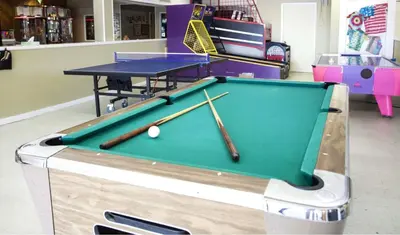 a pool table with two baseball bats and a table at Tanglwood Resort in Hawley