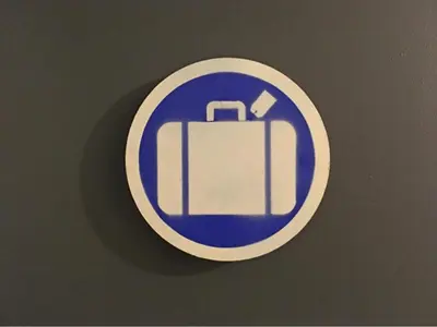 a blue and white sign with a suitcase on a table at American Dream in New York