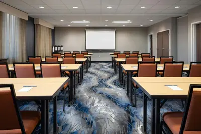 a lecture room with tables and chairs and a screen at Fairfield Inn & Suites by Marriott Towanda Wysox in Towanda