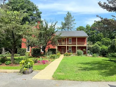 a red house with a garden in front of it at HIllside Farm B & B in Mount Joy
