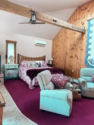 a bedroom with a bed and two chairs at HIllside Farm B & B in Mount Joy