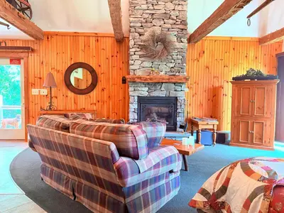a living room with a couch and a stone fireplace at HIllside Farm B & B in Mount Joy