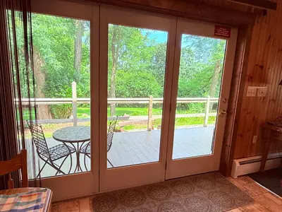 a screened porch with sliding glass doors with a table at HIllside Farm B & B in Mount Joy