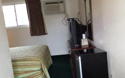 a hotel room with a bed and a tv at Hallmark Motel in Cinnaminson