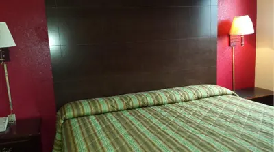 a bedroom with a bed and a red wall at Hallmark Motel in Cinnaminson
