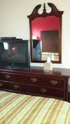 a tv sitting on a dresser with a mirror at Hallmark Motel in Cinnaminson