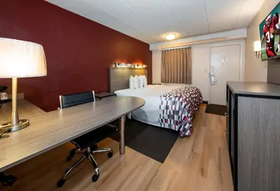 a hotel room with a bed and a desk at Red Roof Inn Edison in Edison