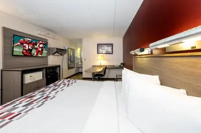 a hotel room with a large bed and a desk at Red Roof Inn Edison in Edison