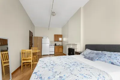a bedroom with a large bed and a kitchen at West 30th Street Guest House in New York