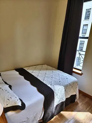 a bed sitting in a room with a window at West 30th Street Guest House in New York