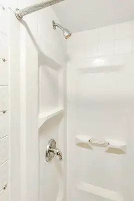 a white bathroom with a shower with a sink at West 30th Street Guest House in New York