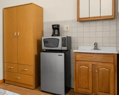 a kitchen with a microwave on top of a refrigerator at West 30th Street Guest House in New York
