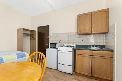 a kitchen with a stove and a sink and a table at West 30th Street Guest House in New York
