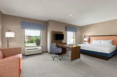 a hotel room with a bed and a desk with a computer at Hampton Inn & Suites Harrisburg in Harrisburg