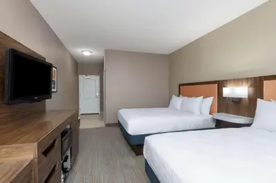 a hotel room with two beds and a flat screen tv at Hampton Inn & Suites Harrisburg in Harrisburg