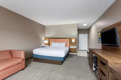 a bedroom with a bed and a flat screen tv at Hampton Inn & Suites Harrisburg in Harrisburg