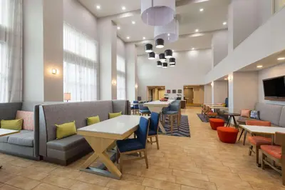 a lobby with tables and chairs and a waiting room at Hampton Inn & Suites Harrisburg in Harrisburg