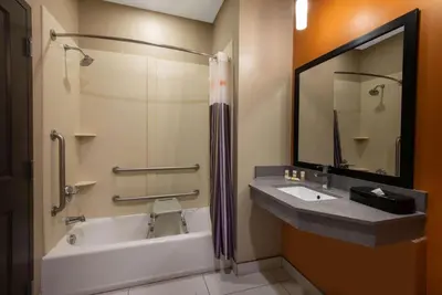 a bathroom with a tub and a sink and a mirror at La Quinta by Wyndham Harrisburg-Hershey in Harrisburg