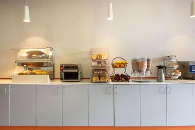 a kitchen with white cabinets and a counter with food at La Quinta by Wyndham Harrisburg-Hershey in Harrisburg