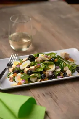 a plate of salad on a table with a glass of wine at Hyatt Place New York/Midtown-South in New York