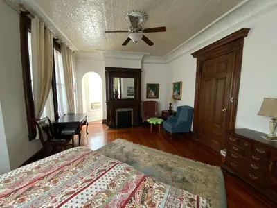 a bedroom with a bed and a ceiling fan at Fort Pl B&B and Gallery in Staten Island