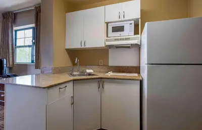 a kitchen with white cabinets and a refrigerator at Extended Stay America Suites - Edison - Raritan Center in Edison