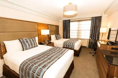 a hotel room with two beds and a television at The Belvedere Hotel in New York