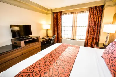 a hotel room with a bed and a flat screen tv at The Belvedere Hotel in New York